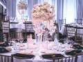 Elegancka sala weselna z białymi kwiatami i złotymi talerzami. Jak wybrać idealną salę weselną na co patrzeć podczas pierwszej wizyty?