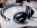 Słuchawki na otwartym zeszycie. Idealne do planowania, jak przygotować listę piosenek "must play" i "do not play" dla DJ-a.