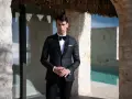 Elegancki mężczyzna w smokingu, idealny przykład stroju black tie na wesele. Różnica między ubiorem black tie a cocktail dress dla gości weselnych jest widoczna.