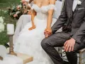 Para spowiedzi przedślubnej lub formalności w USC: panna młoda w koronkowej sukni i pan młody w garniturze trzymają się za ręce.