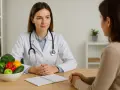 Lekarka z miską warzyw i owoców rozmawia z pacjentką. Unikaj skutków niepoinformowania o diecie specjalnej przed weselem.