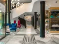 Eleganckie wnętrze bankietowe z niebieską kanapą i czerwonymi fotelami. Przyczyny powrotu do stylistyki art deco w nowoczesnych wnętrzach bankietowych widać w geometrycznych wzorach i luksusowych materiałach.