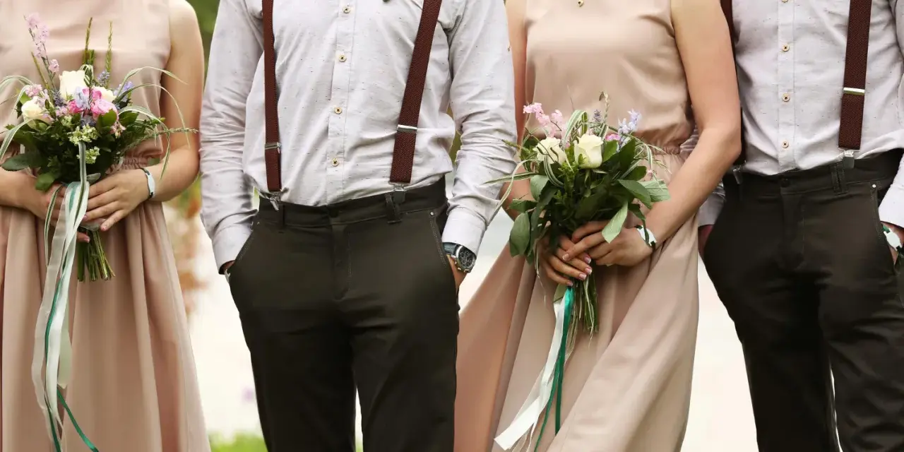 Eleganckie stroje pary z bukietami. Brak informacji o dress codzie na zaproszeniu mógłby prowadzić do takich stylizacji.