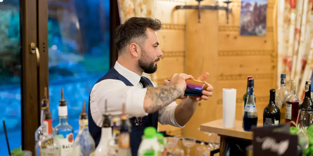 Barman przygotowuje drinki. Czy warto inwestować w barmana i drink bar na weselu? Koszty a efekt - zobacz!