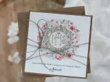 Eleganckie zaproszenie na Komunię dla Matki Chrzestnej. Wzór z motywem kwiatowym i symbolem IHS. Idealne, by pokazać, jak wypisać tekst zaproszenia na komunię dla chrzestnych.