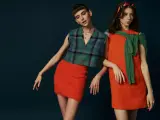Dwie modelki w stylizacjach inspirowanych modą lat 60. Jedna w kraciastej kamizelce i pomarańczowej spódniczce, druga w pomarańczowej sukience i zielonym sweterku.