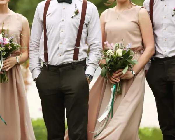 Eleganckie stroje pary z bukietami. Brak informacji o dress codzie na zaproszeniu mógłby prowadzić do takich stylizacji.