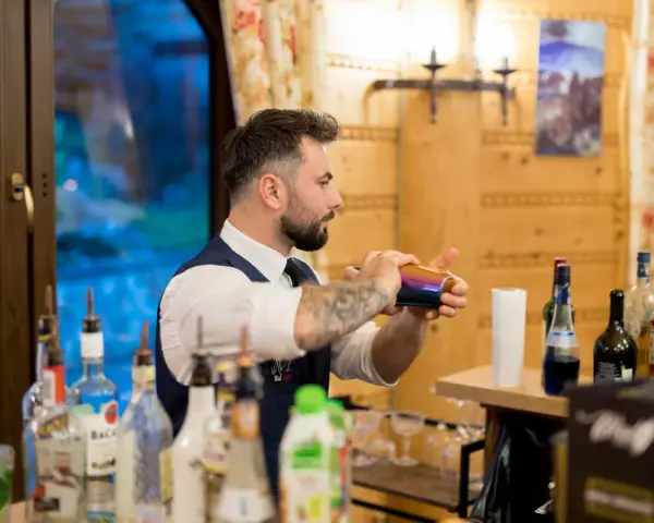 Barman przygotowuje drinki. Czy warto inwestować w barmana i drink bar na weselu? Koszty a efekt - zobacz!