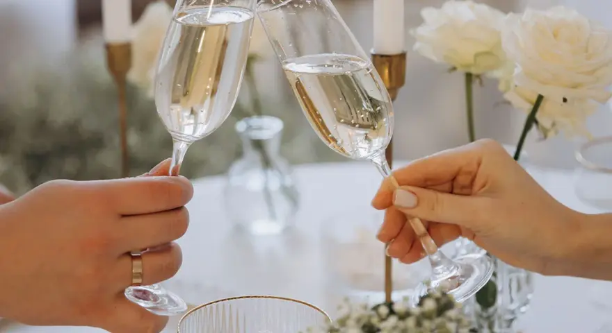 Wznoszenie toastu szampanem. Jakie są zasady serwowania alkoholu na weselu? Wino, wódka czy whisky – wybór należy do pary młodej.