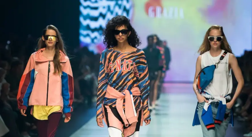 Modelki na wybiegu prezentują stylizacje, które idealnie sprawdzą się, jak się ubrać na imprezę w stylu lat 90. Kolorowe bluzy, dresy i neonowe dodatki.
