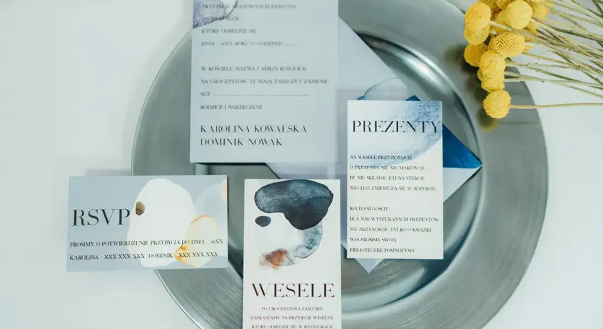 Próbki zaproszeń ślubnych na talerzu. Czy warto zamawiać zaproszenia z próbkami przed finalnym drukiem? Zobacz, jak wyglądają detale.