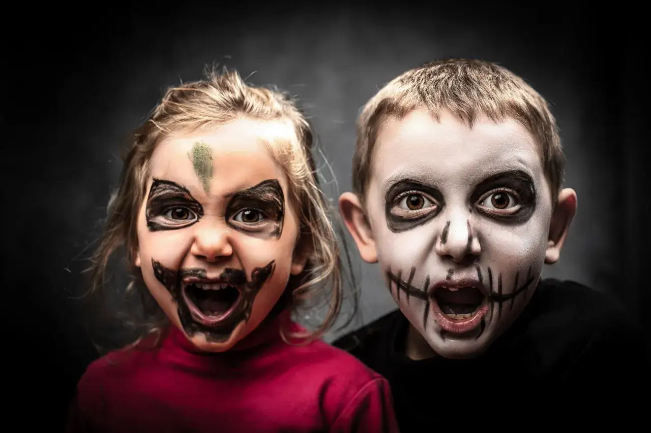 Dwoje dzieci w przerażających makijażach, gotowych na Halloween. Ich stroje na halloween dla dzieci są idealne na straszenie!