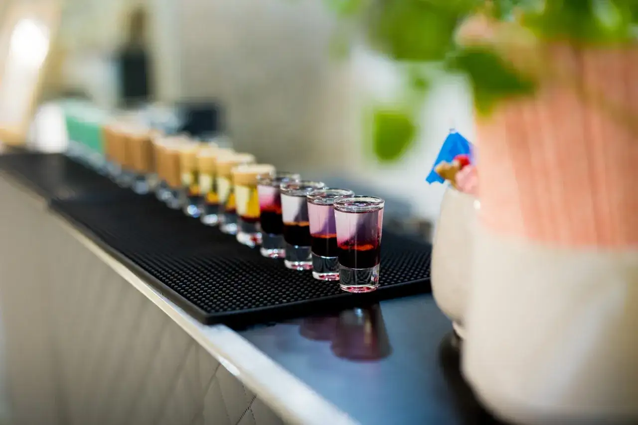 Kolorowe shoty na weselnym barze. Czy warto inwestować w barmana i drink bar na weselu? Koszty a efekt - zobacz!