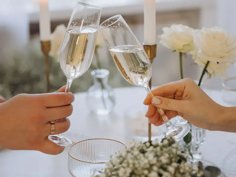 Wznoszenie toastu szampanem. Jakie są zasady serwowania alkoholu na weselu? Wino, wódka czy whisky – wybór należy do pary młodej.
