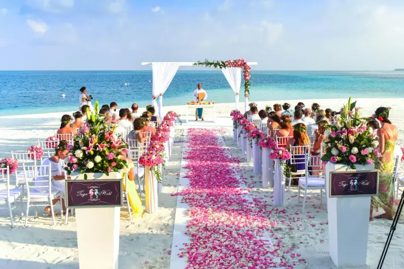 Piękna plażowa ceremonia ślubna. Kwiaty, płatki róż i białe krzesła tworzą romantyczną atmosferę. To wszystko, co potrzebne do ślubu cywilnego w rajskim otoczeniu.